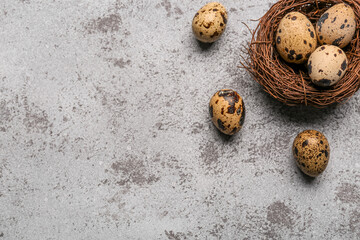 Nest with fresh quail eggs on grunge background