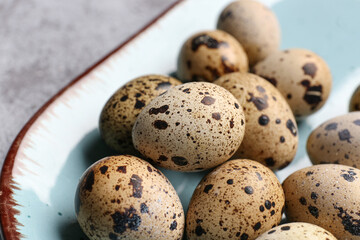 Obraz premium Plate with fresh quail eggs on table, closeup