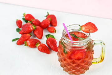 Mason jar of tasty strawberry drink with fresh berries on white background