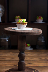 Sweet dessert on display in vintage style on a wooden stand. Rustic pastry shop style