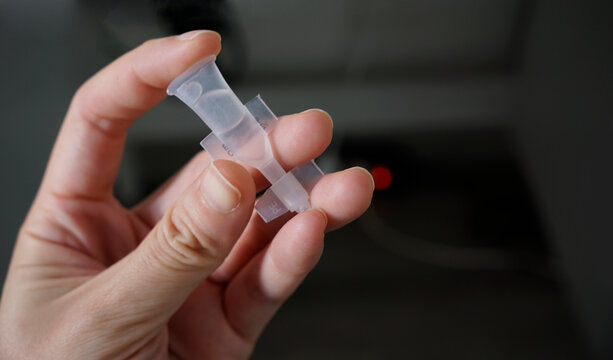 Cropped hand holding a eye drop capsule