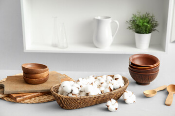 Basket of cotton flowers with kitchen dishes on table