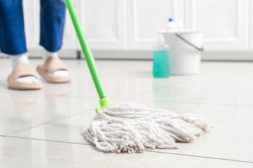 Woman mopping floor in room, closeup