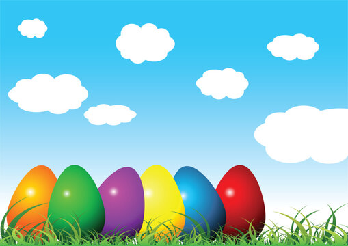 Easter eggs on grass with different colors over cloudy blue sky