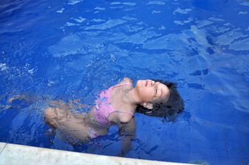 menina feliz a nadar na piscina 