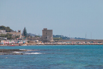 Torre Vado desde la Marina di Salve en un caluroso día de verano, Puglia, Italia. Bañistas tomando el sol o dándose un baño en la conocida como Las Maldivas de Salento.