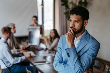 Portrait of confident young businessman during team meeting.