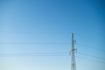 Wires and power pole against a cloudless blue sky