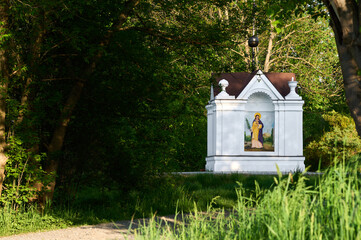 A roadside shrine among the grass against the background of tree
