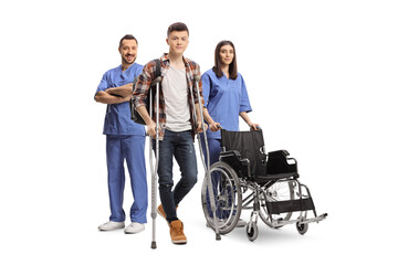 Young male patient with leg injury standing in front of health care workers with a wheelchair