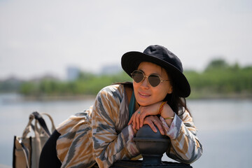 Portrait of a young Asian (Kazakh) woman in sunglasses and a hat. Portrait of a happy girl.