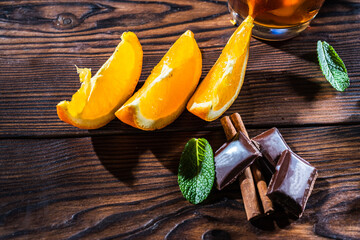 Orange slices on the table. Chocolate circles and cinnamon sticks on the table.