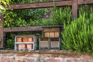 Various insect hotels, bug hotels, insect houses in a garden. Natural gardening concept.