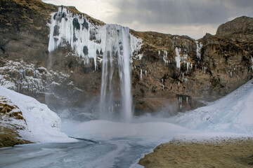 Iceland waterfall in winter with ice and snow