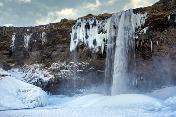 Iceland waterfall in winter with ice and snow