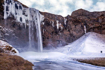Iceland waterfall in winter with ice and snow