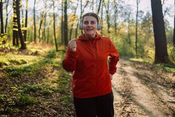 Calm, music and fitness person in nature for mental health, wellness and breathing, forest trees and fresh air. Mockup, sports and athlete woman thinking or listening to audio for running inspiration