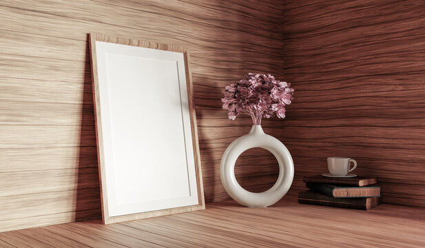 Empty wooden picture frame mockup on desk with vase, pink flower, books, and ceramic bowl, natural shadow on wood wall