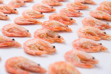 Frozen shrimps in ice on a white background. A lot of royal shrimp close-up.