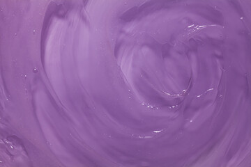 Liquid cosmetic gel or vaseline or balm smudge texture on light purple background