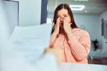 An overweight woman talking with a doctor about her health and crying.