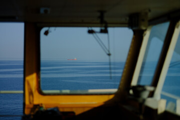 A view from the wheelhouse at sea during the sunrise.