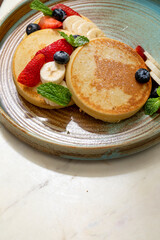 fluffy pancakes with fruits on a sunny morning 