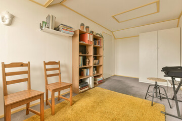 a living room with two wooden chairs and a small table in front of the wall that has been painted white
