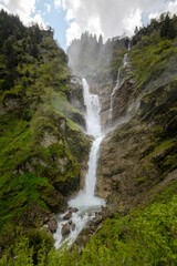 Sommer in den Alpen mit Wiesen, Wasserfällen und Gletschern