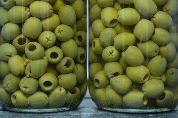 Glass jars with green olives.
