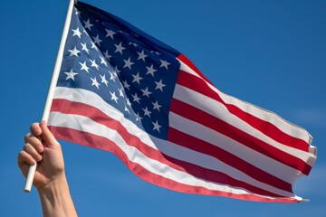 A close-up of a veteran's hand holding an American flag, with a backdrop of a clear blue sky, representing patriotism and honor. Generative AI