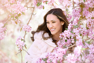 beautiful woman next to cherry blossom tree