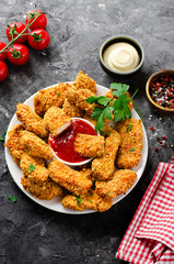 Delicious Crispy Fried Breaded Chicken Breast Strips with Ketchup on Dark Background