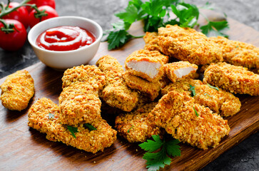 Delicious Crispy Fried Breaded Chicken Breast Strips with Ketchup on Dark Background