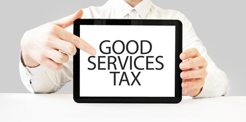 Fototapeta na wymiar Text GOOD SERVICES TAX on tablet display in businessman hands on the white background. Business concept