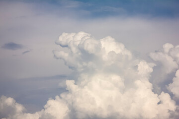 A huge, heapy cloud in the form of a dinosaur, Godzilla opening its mouth, looking up