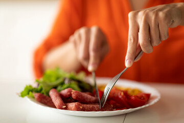 Unrecognizable african american woman eating tasty lunch in kitchen