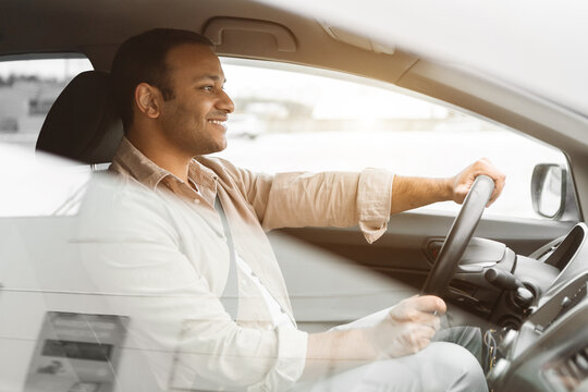 Cheerful Middle Eastern Man Driving Car Sitting In Driver's Seat