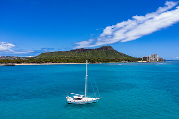 Fototapeta na wymiar Sailboat Serenity: Majestic Diamond Head Frames Hawaiian Paradise
