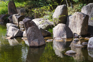 large rocks at a pond of a landscaped Japanese garden