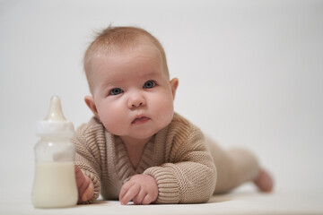 Newborn baby drinks milk from a bottle.