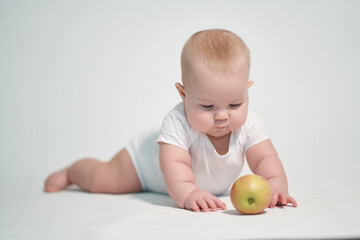 Baby 7 months old with an apple. photography on a white background