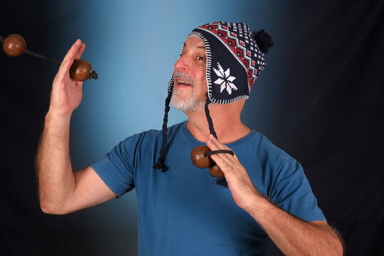 happy bald man with white beard Peruvian cap on his head playing musical instrument asalato looking forward with good expression