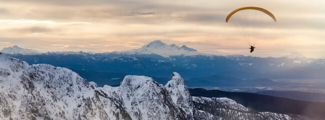 Paraglider flying over Canadian Mountain Landscape. Extreme Adventure Composite.