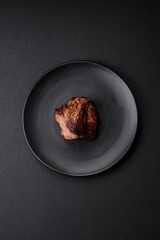Delicious beef steak with salt, spices and herbs on a ceramic plate