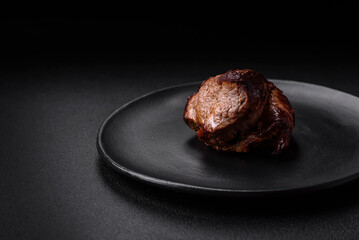 Delicious beef steak with salt, spices and herbs on a ceramic plate