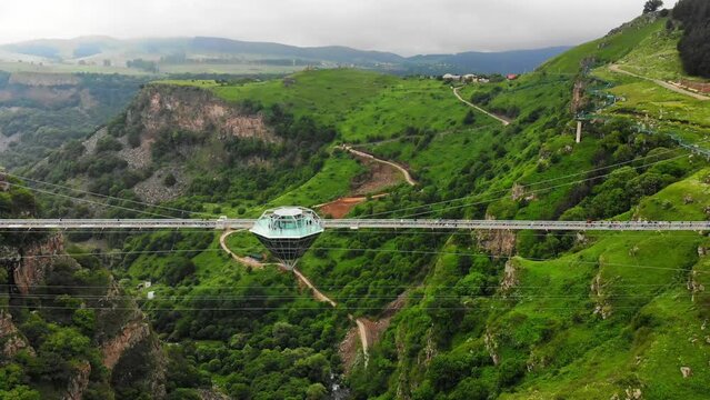 Dashbashi, Georgia - 19th june, 2022: Aerial fly over Diamond shape platform on glass bridge over scenic dashbashi valley in Georgia countryside. Famous modern bridge over valley in caucasus