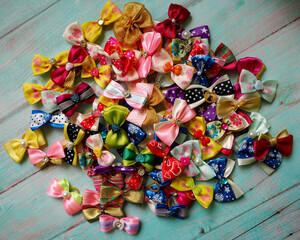 a lot of bright multi-colored small bows for top ready dogs on a blue table.  view from above .  accessories