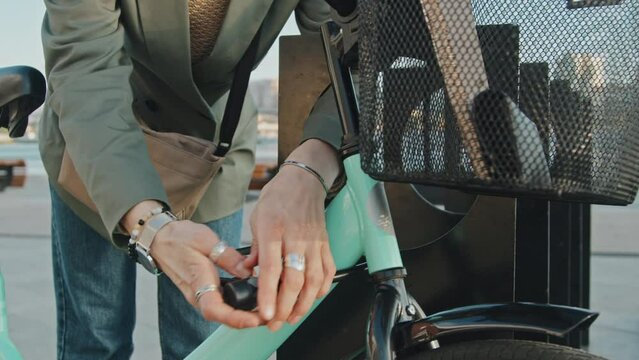 Medium section shot of unrecognizable female office worker locking her bicycle using anti-theft device