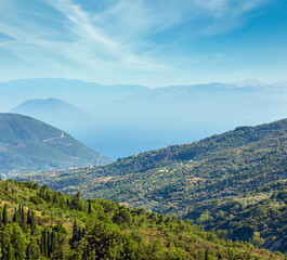 Obraz premium Misty summer hilly coast panorama (Greece, Lefkada). View from up.